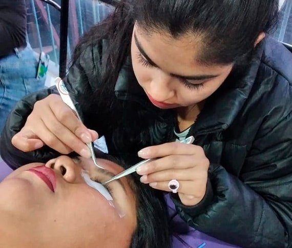 Persona manipulando un objeto pequeño con una herramienta, posiblemente en un espacio interior compartido.