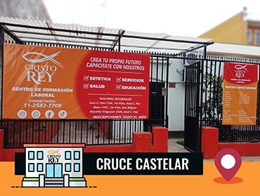 La entrada de la Sucursal en Cruce Castelar. La entrada tiene una reja de metal negro con dos grandes carteles naranjas colocados en ella. Los carteles contienen información sobre el centro, como detalles de contacto, servicios ofrecidos y ubicación.